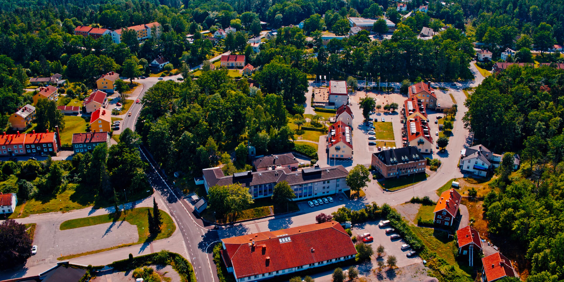 Bild från ovan över samhälle. Ett mindre brukssamhälle där gator och hus finns mellan större skogsdungar.