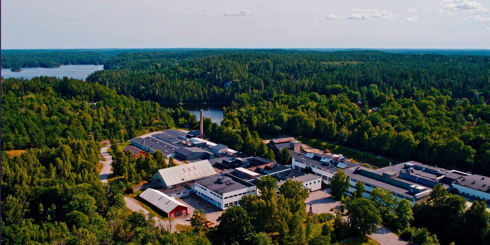 Bild från ovan. Bild på industrikomplex. I bakgrunden sträcker sig skogen till horisonten och man kan se diverse vattenkroppar.